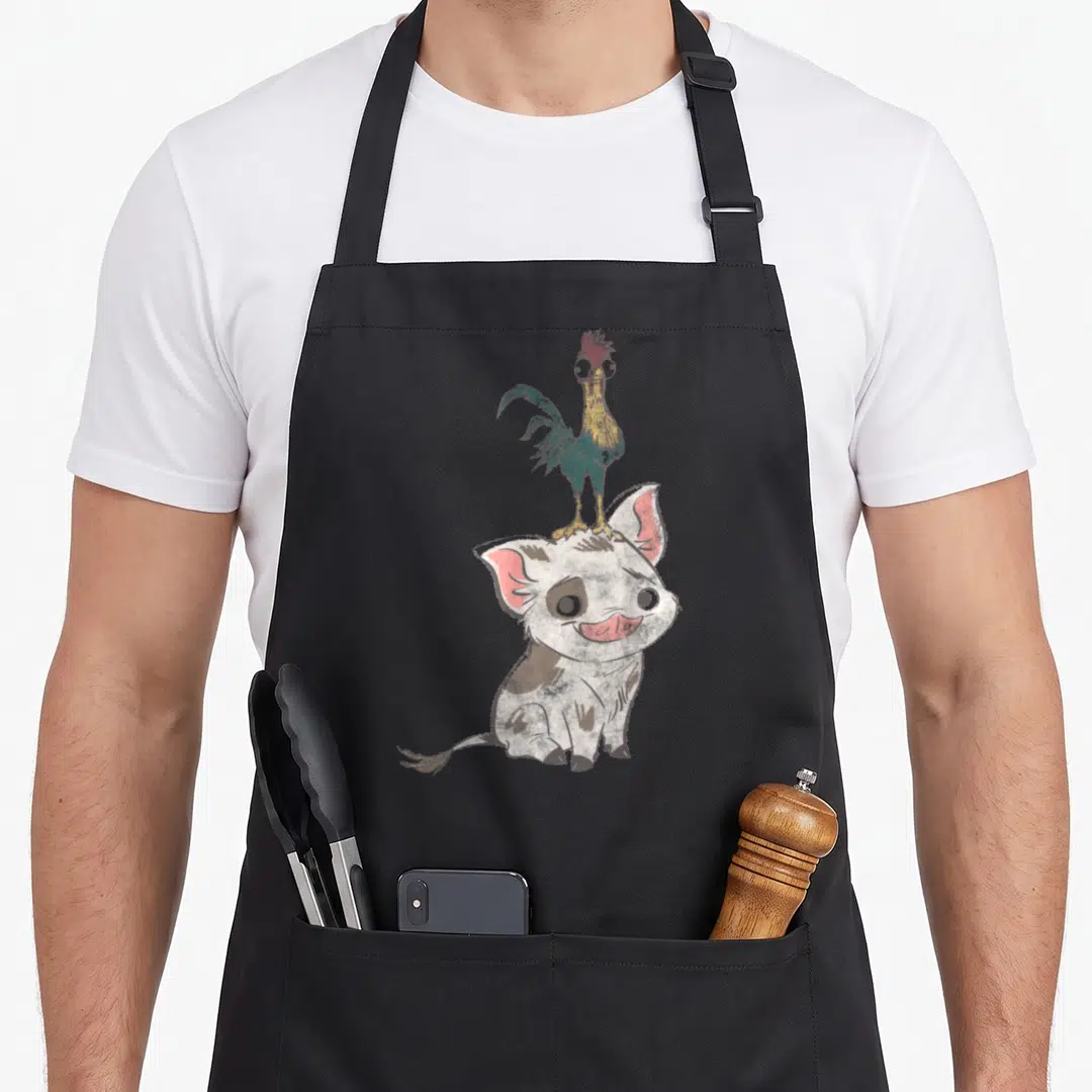 Pua simple apron - Cartoon pig sitting with colorful rooster standing on head in white brown blue and yellow — shown on a black cotton canvas apron against a white background