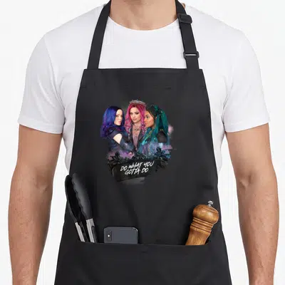 Uma novelty apron - Three women with colorful hair above white text on ornate black frame — shown on a black cotton canvas apron against a white background