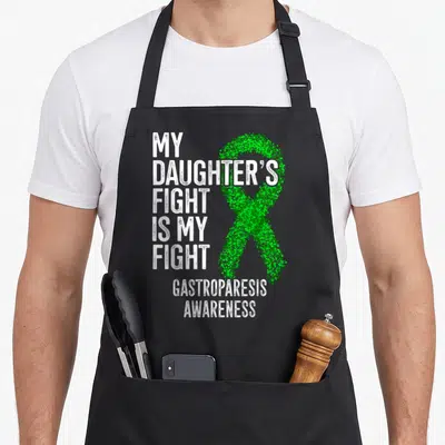 Fight gastroparesis awareness apron - White stacked text My Daughters Fight Is My Fight beside a green stippled ribbon — shown on a black cotton canvas apron against a white background