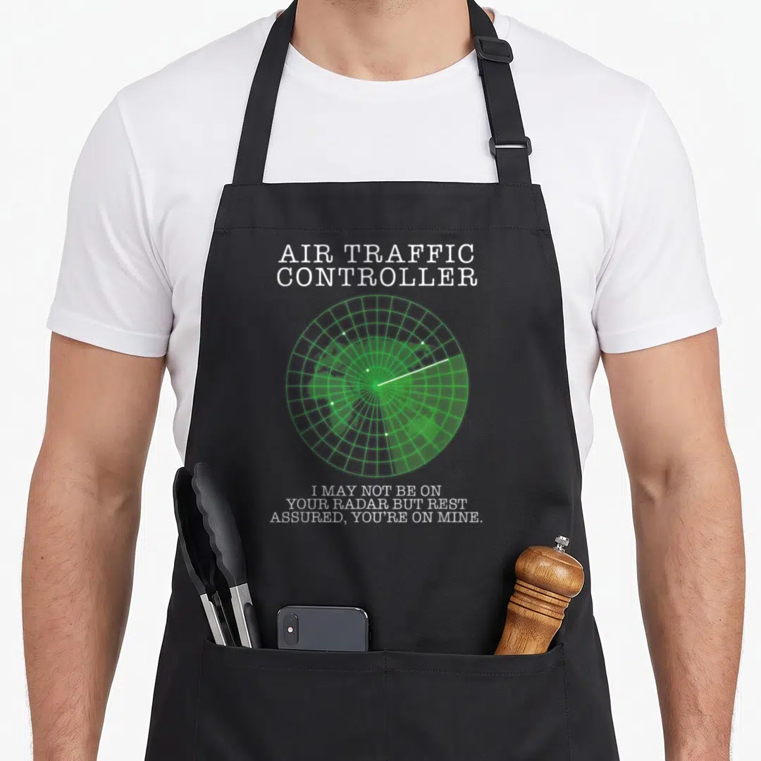 Air aviation apron - Green radar screen with white text Air Traffic Controller and pun about being on your radar — shown on a black cotton canvas apron against a white background