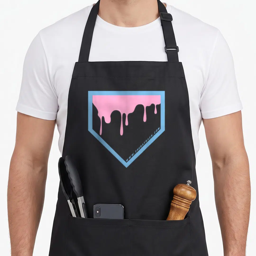 Plate drip apron - Pink dripping liquid inside light blue home plate shield outline — shown on a black cotton canvas apron against a white background