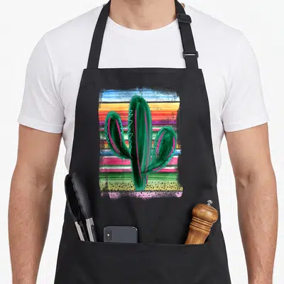Serape cactus apron - Green watercolor cactus with pink and blue accents over horizontal multicolored stripes — shown on a black cotton canvas apron against a white background