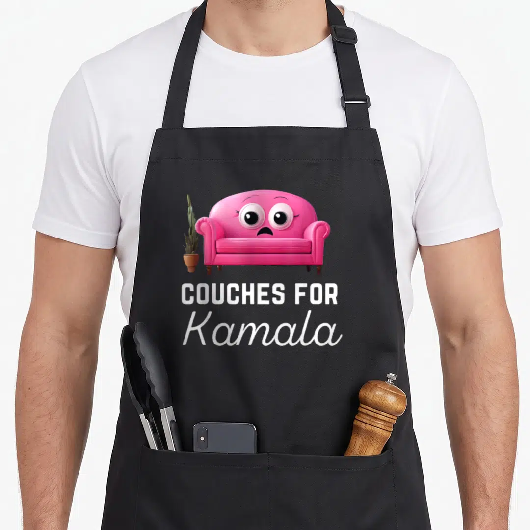 Kamala meme apron - Pink cartoon couch with face and COUCHES FOR Kamala text beside a cactus — shown on a black cotton canvas apron against a white background