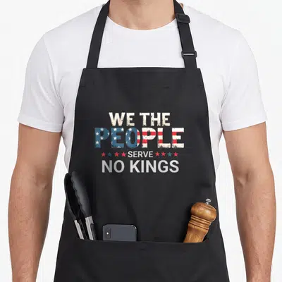 Democracy king apron - Stacked We The People Serve No Kings text with flag fill and stars — shown on a black cotton canvas apron against a white background