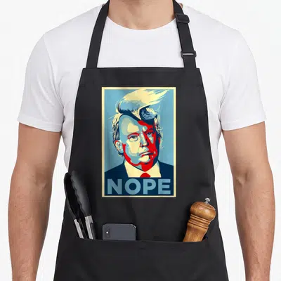 Nope hair apron - Retro red blue cream Trump portrait with NOPE text bar at bottom — shown on a black cotton canvas apron against a white background