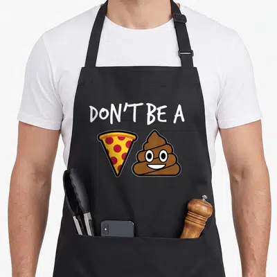 Retro pizza apron - Cartoon pizza slice and brown poop emoji under white DON'T BE A text — shown on a black cotton canvas apron against a white background