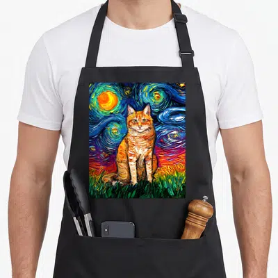 Tabby kitty cat apron - Orange tabby cat sitting on green grass against a swirling blue and yellow starry night — shown on a black cotton canvas apron against a white background