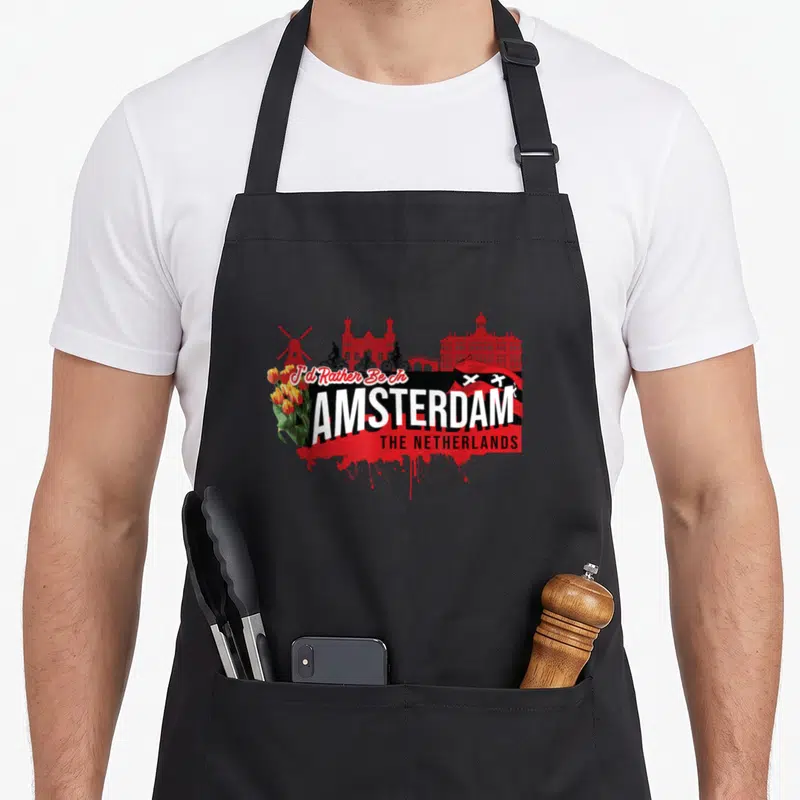Rather netherlands apron - Red Amsterdam skyline with cyclists, tulips, flag, and stacked text reading I'd Rather Be — shown on a black cotton canvas apron against a white background