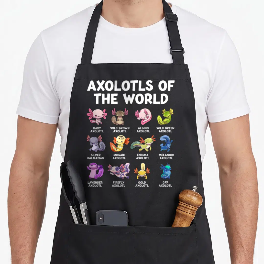 Animal kawaii apron - Twelve cartoon axolotls in a grid with labels like Wild Brown, Albino, Silver Dalmatian, and GFP — shown on a black cotton canvas apron against a white background