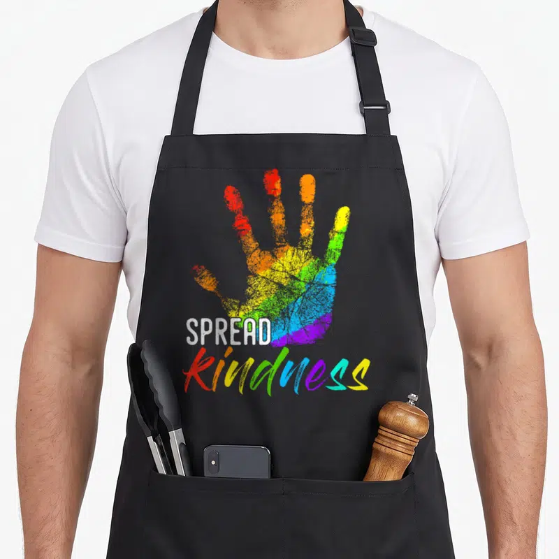 Anti teacher apron - Rainbow handprint with white spread and rainbow kindness text — shown on a black cotton canvas apron against a white background