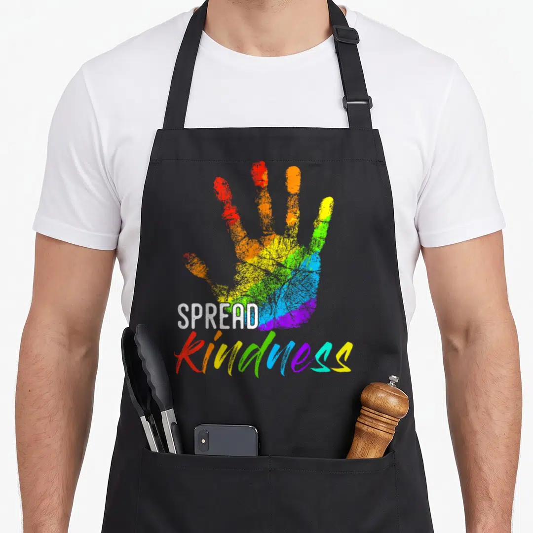 Anti teacher apron - Rainbow handprint with white spread and rainbow kindness text — shown on a black cotton canvas apron against a white background