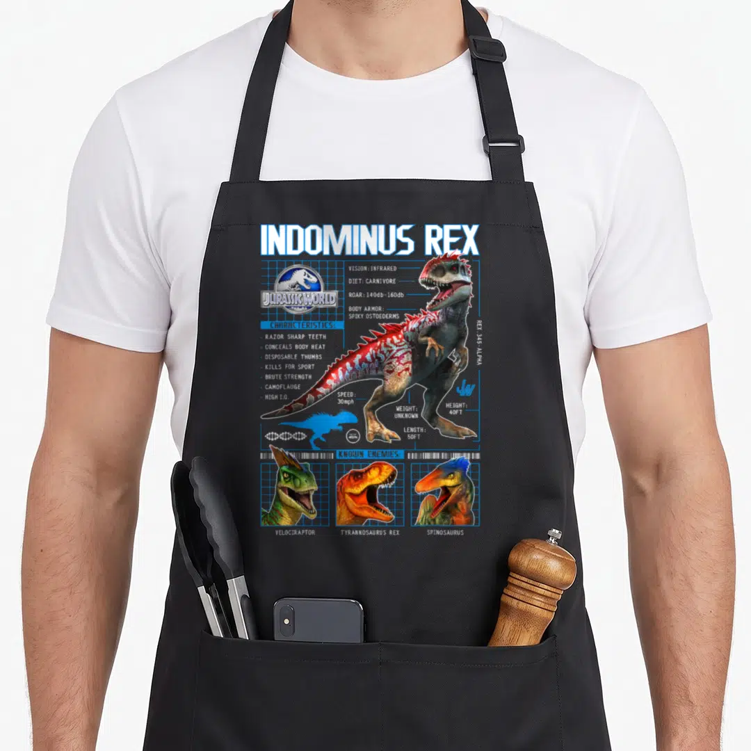 Indominus t-rex apron - Indominus Rex schematic with stats, three enemy heads, and blue grid lines — shown on a black cotton canvas apron against a white background