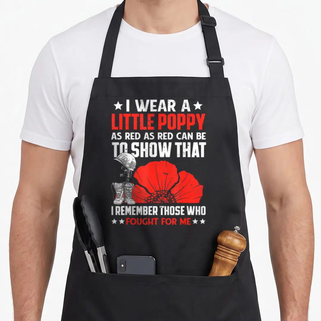 Memorial veterans day patriotic american flag apron - Red poppy and military helmet with I Remember Those Who Fought — shown on a black cotton canvas apron against a white background