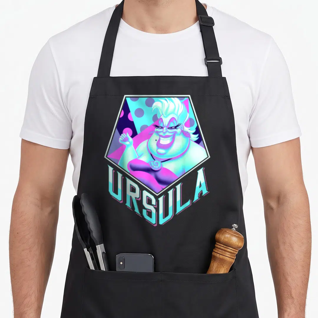 Pop mermaid apron - Ursula character in white hexagon with URSULA text in cyan purple white cartoon style — shown on a black cotton canvas apron against a white background