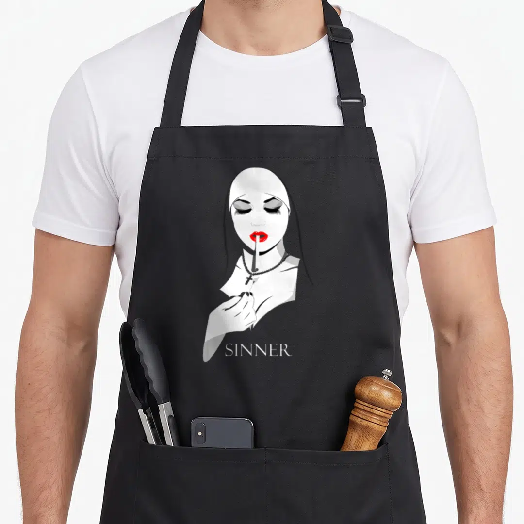 Sinner master apron - Stylized nun smoking cigarette with red lips and SINNER text in white, red, and black — shown on a black cotton canvas apron against a white background