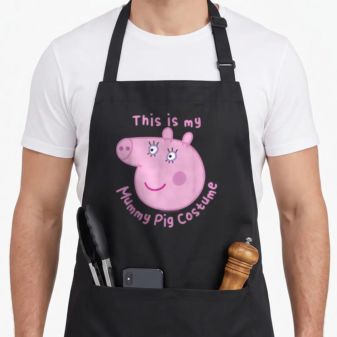 Funny halloween mummy and me aprons - Pink pig face with arched text This is my Mummy Pig Costume in cartoon style — shown on a black cotton canvas apron against a white background