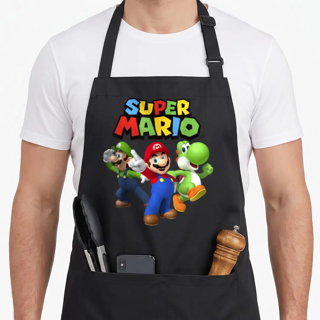 Cute shot apron - Super Mario logo in red blue green yellow above Mario Luigi and Yoshi standing in a group — shown on a black cotton canvas apron against a white background