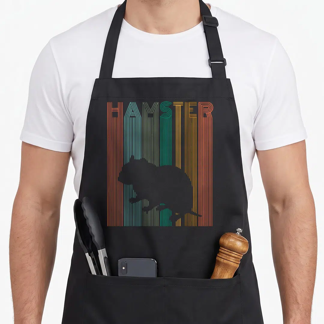 Cute crazy hamster man apron - Grey hamster silhouette over vertical rainbow stripes with HAMSTER text at top — shown on a black cotton canvas apron against a white background