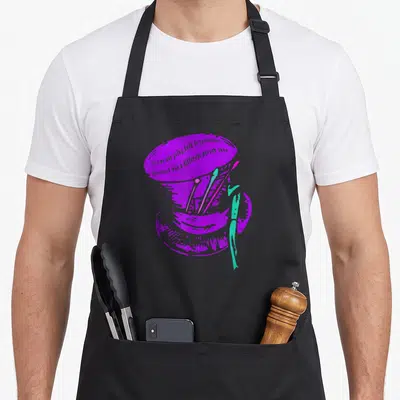 Mad hatter alice wonderland apron - Purple top hat with paintbrushes and artist quote in cartoon style — shown on a black cotton canvas apron against a white background