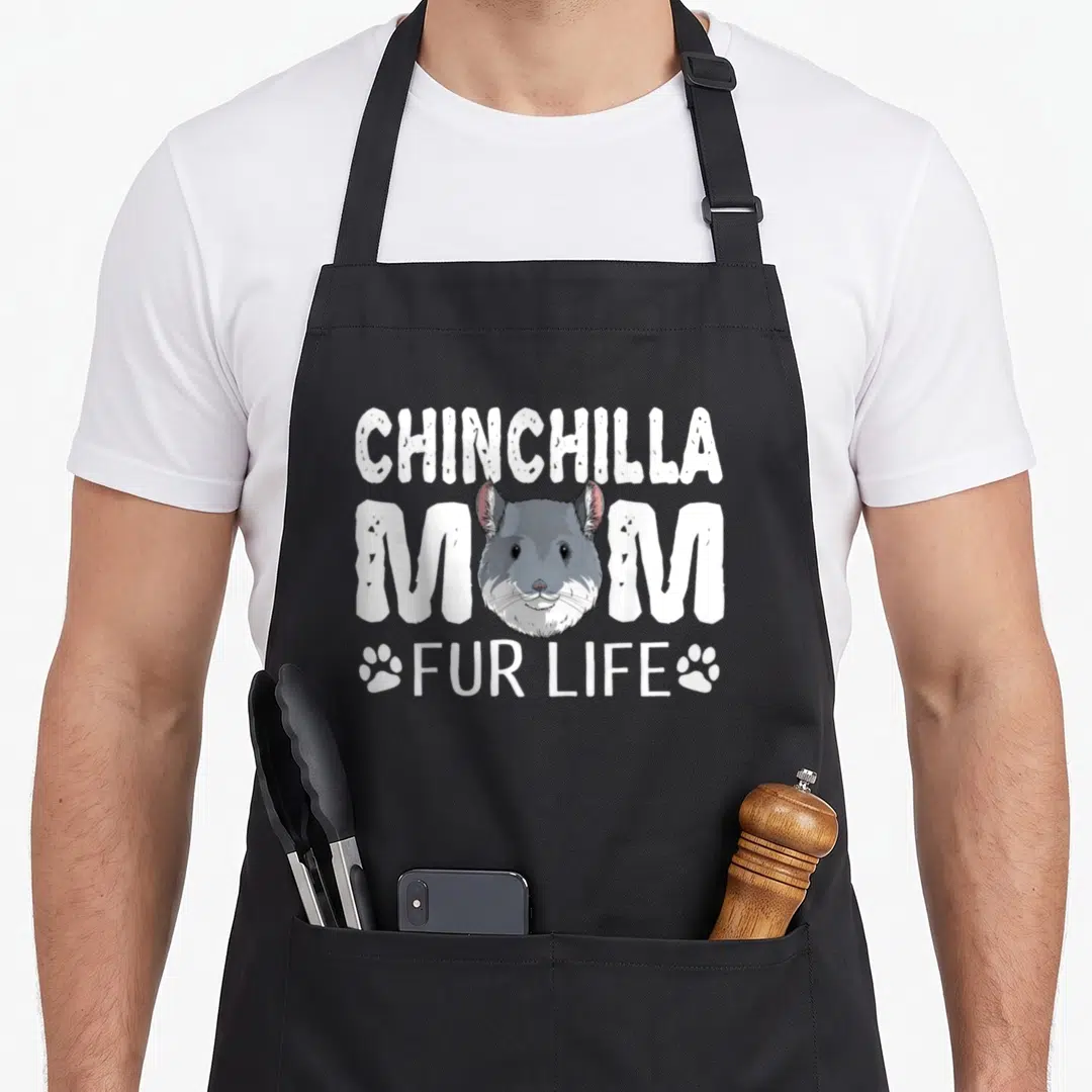 Fur mother's day aprons - Chinchilla head graphic with white text reading Chinchilla Mom Fur Life flanked by paw prints — shown on a black cotton canvas apron against a white background
