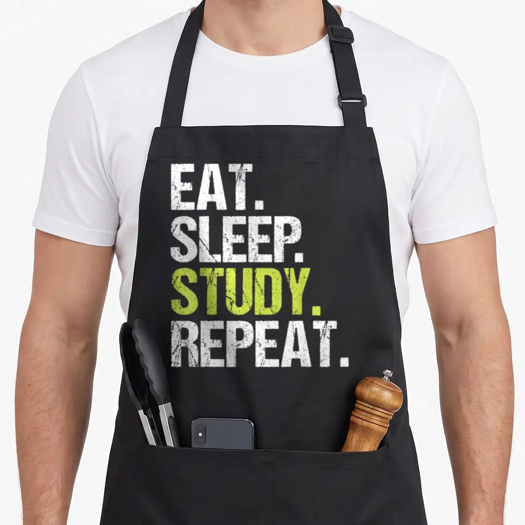 Sleep christmas apron - EAT SLEEP STUDY REPEAT text in white and lime green distressed font — shown on a black cotton canvas apron against a white background