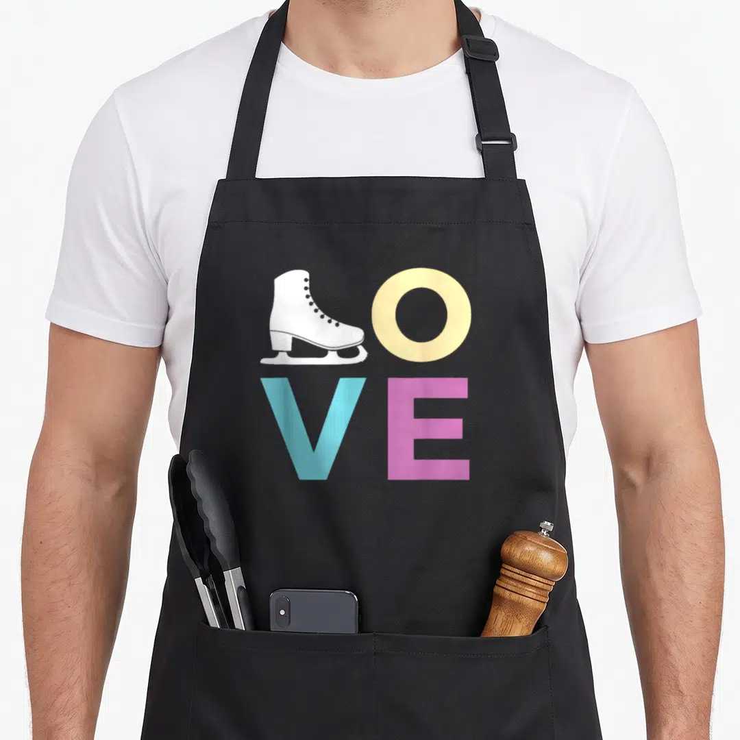 Ice figure skating apron - LOVE text with white skate replacing L, yellow O, blue V, pink E — shown on a black cotton canvas apron against a white background