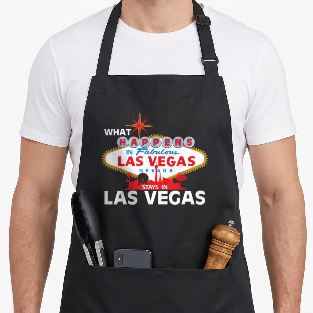 Stay las vegas apron - Retro Las Vegas diamond sign with red skyline silhouette and stacked text — shown on a black cotton canvas apron against a white background
