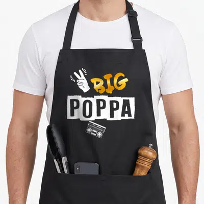 Hop 2nd apron - Gold BIG POPPA text with white peace sign hand and boombox graphic — shown on a black cotton canvas apron against a white background