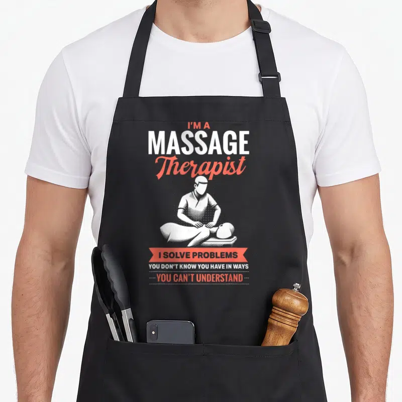 Funny masseuse massage therapist apron - Red and white text with line art of therapist pressing on patient back — shown on a black cotton canvas apron against a white background
