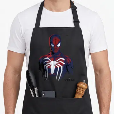 Painted game aprons - Spider-Man portrait in red and blue with distressed splatter and MARVEL SPIDER-MAN text — shown on a black cotton canvas apron against a white background