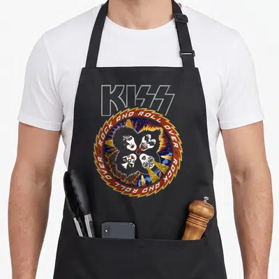 Kiss music apron - KISS logo above circular saw blade border with four faces, fire, and starry space background — shown on a black cotton canvas apron against a white background