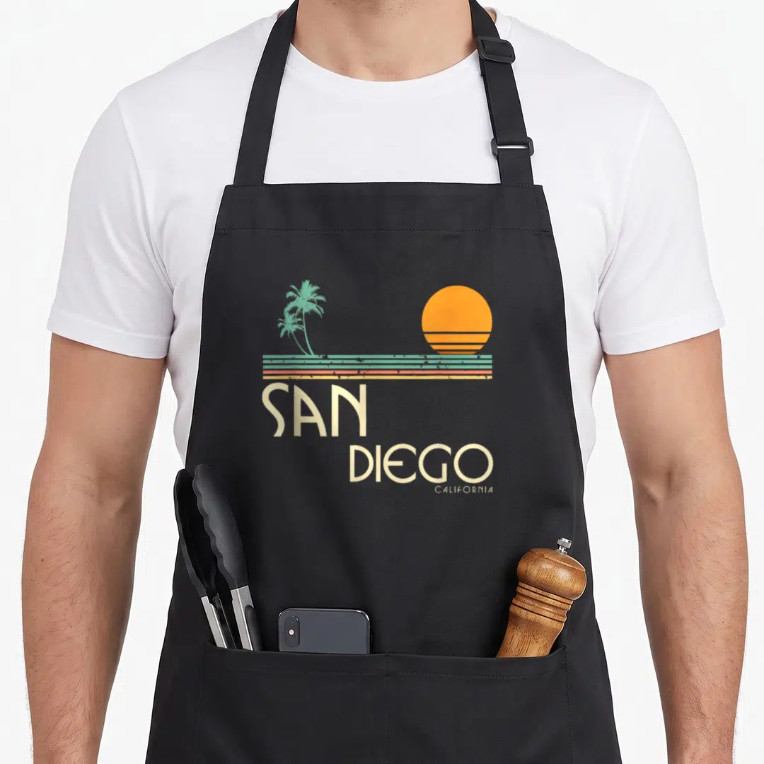 California san diego apron - Retro orange sun teal palms three stripes San Diego California text — shown on a black cotton canvas apron against a white background