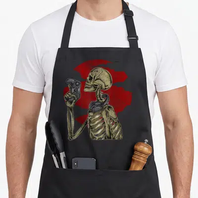 Gamer skeleton video game apron - Beige skeleton holding grey controller in front of distressed red circle — shown on a black cotton canvas apron against a white background