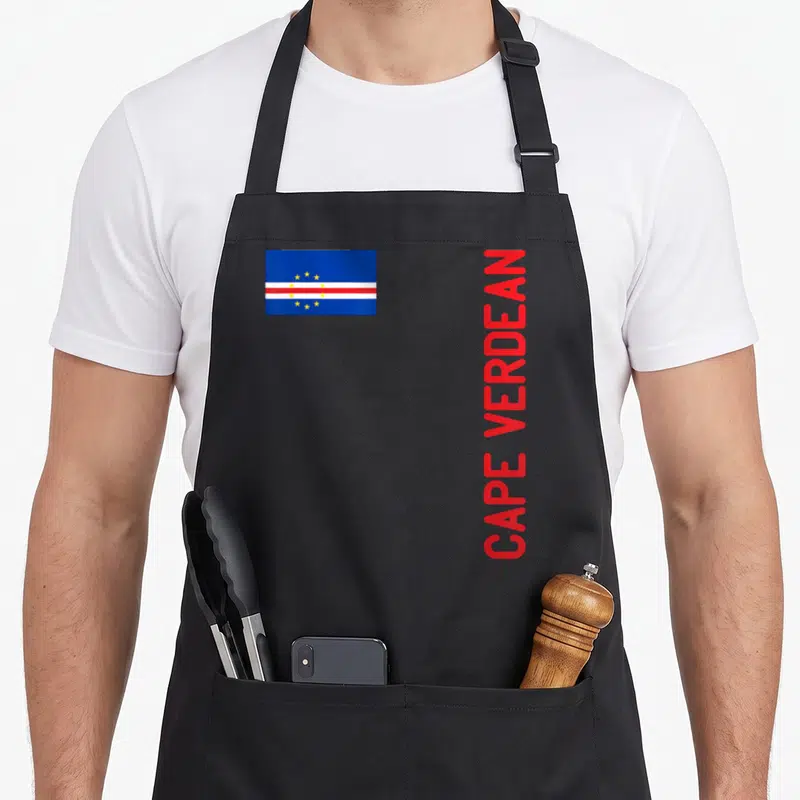 Flag root cape verde apron - Cape Verde flag and vertical red CAPE VERDEAN text on black background — shown on a black cotton canvas apron against a white background