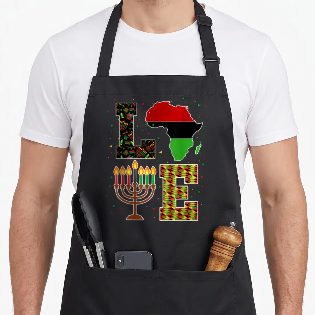 Kwanzaa african grey apron - LOVE spelled with Africa map, menorah, and patterned letters in red green yellow black — shown on a black cotton canvas apron against a white background