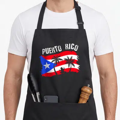Distressed frog aprons - PUERTO RICO text over distressed red white blue flag with grey palm trees and frog silhouette — shown on a black cotton canvas apron against a white background