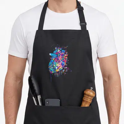 Hitta workout motivation apron - Anatomical heart in multicolored paint splatter with blue red yellow pink purple drips — shown on a black cotton canvas apron against a white background