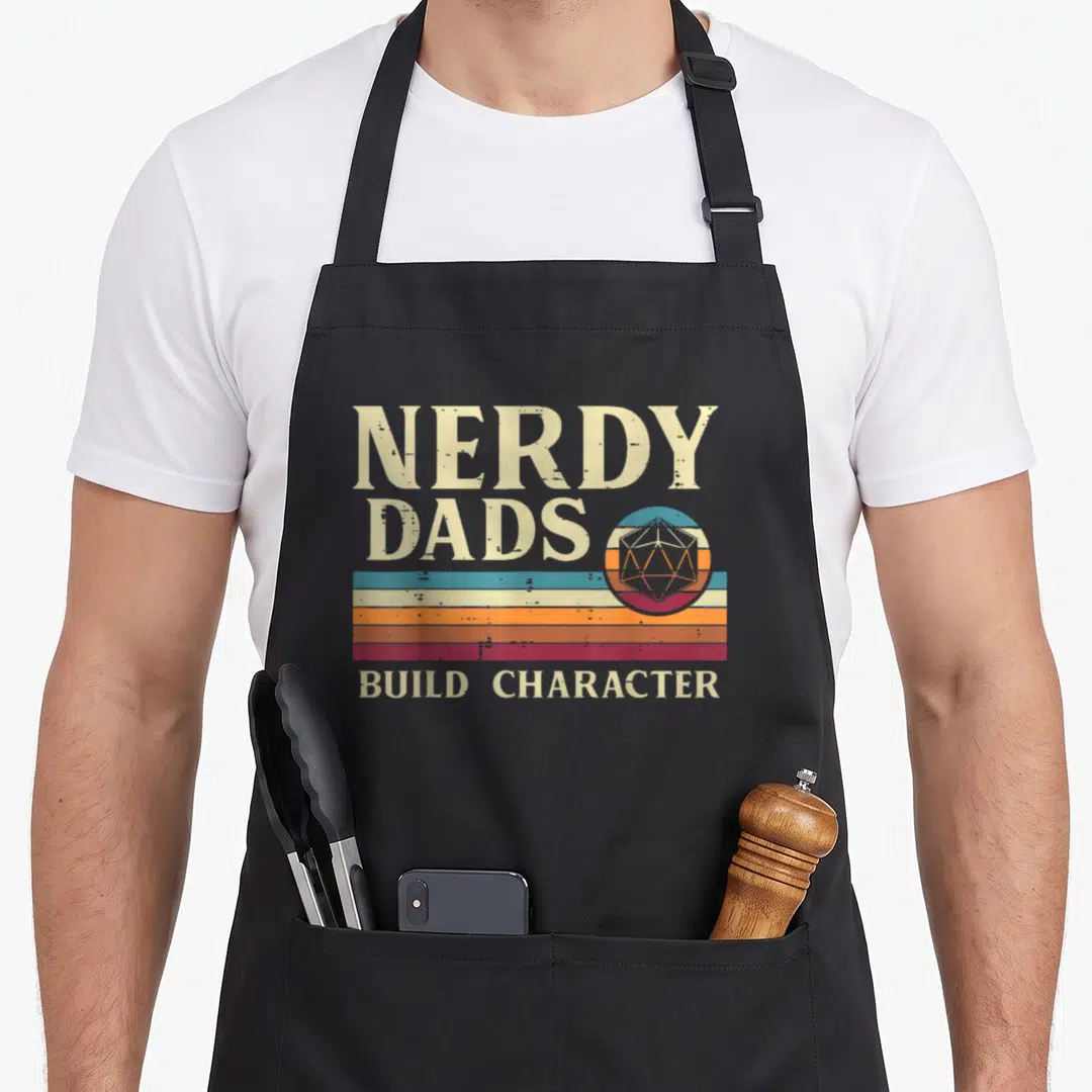 Nerdy grill daddy apron - Retro d20 die over beige teal orange maroon stripes with NERDY DADS BUILD CHARACTER text — shown on a black cotton canvas apron against a white background