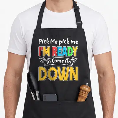 Pick novelty apron - Stacked colorful text reading Pick Me pick me I M READY To Come On DOWN with white banner — shown on a black cotton canvas apron against a white background