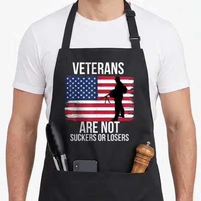 Veteran apron or apron - VETERANS ARE NOT SUCKERS OR LOSERS text over distressed flag with black soldier silhouette — shown on a black cotton canvas apron against a white background