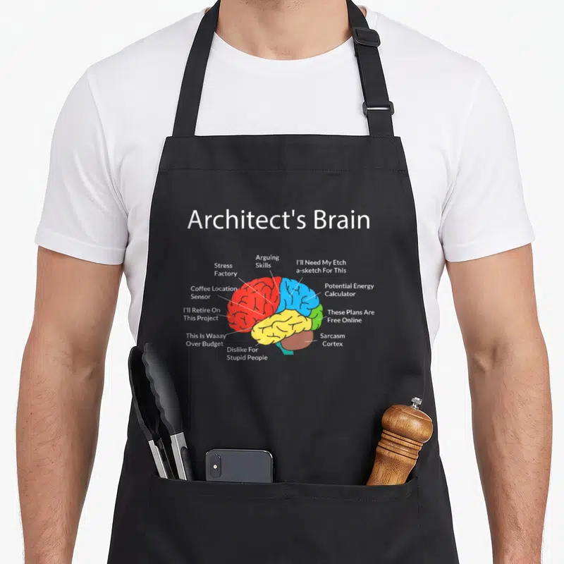 Architect student aprons - Cartoon brain labeled with sarcasm cortex stress factory and budget jokes — shown on a black cotton canvas apron against a white background