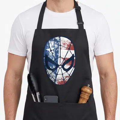Face american flag apron - Distressed mask graphic in blue white and red with web pattern lines — shown on a black cotton canvas apron against a white background