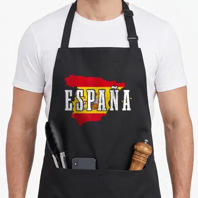 Map spanish aprons - ESPAÑA text over map filled with red yellow white flag colors and coat of arms — shown on a black cotton canvas apron against a white background