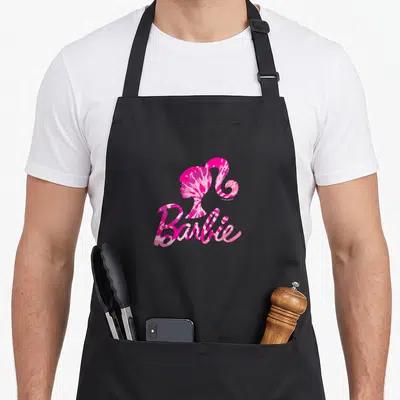 Silhouette tie dye apron - Pink and white tie-dye Barbie silhouette profile above script logo text on black fabric — shown on a black cotton canvas apron against a white background