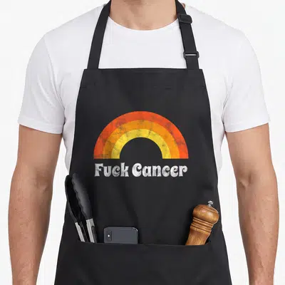 Cute distressed breast cancer awareness aprons - Retro rainbow arch in orange yellow and white above distressed Fuck — shown on a black cotton canvas apron against a white background