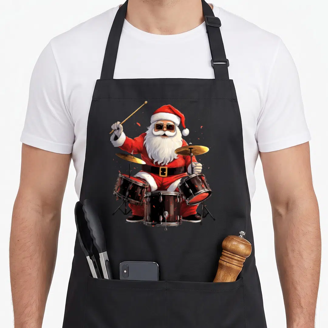 Drummer santa claus apron - Cartoon Santa Claus in red suit and sunglasses playing black drum kit with gold cymbals — shown on a black cotton canvas apron against a white background