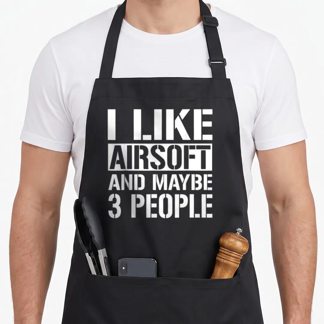 Airsoft maybe gun apron - White stacked text reading I Like Airsoft And Maybe 3 People with inverted center line — shown on a black cotton canvas apron against a white background