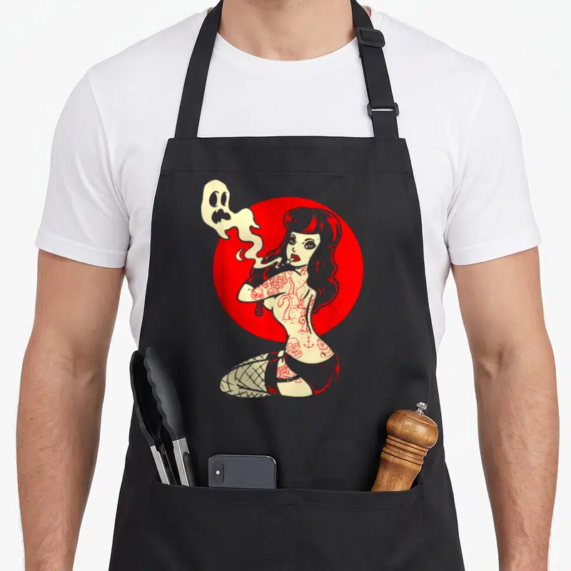Horror goth apron - Tattooed woman smoking ghost smoke red circle cartoon pinup — shown on a black cotton canvas apron against a white background