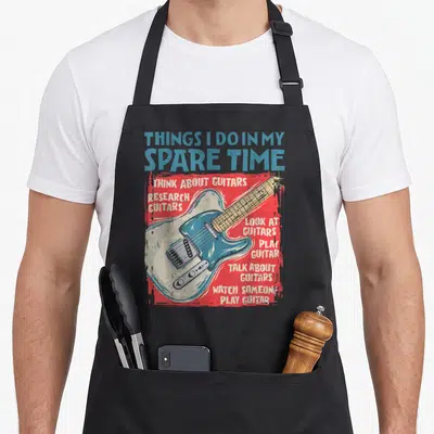 Guitar spare time apron - Retro electric guitar graphic with text listing things I do in my spare time on red background — shown on a black cotton canvas apron against a white background