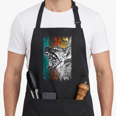 Hyena animal idea apron - Distressed white wolf head over five vertical stripes in teal, brown, orange, yellow — shown on a black cotton canvas apron against a white background